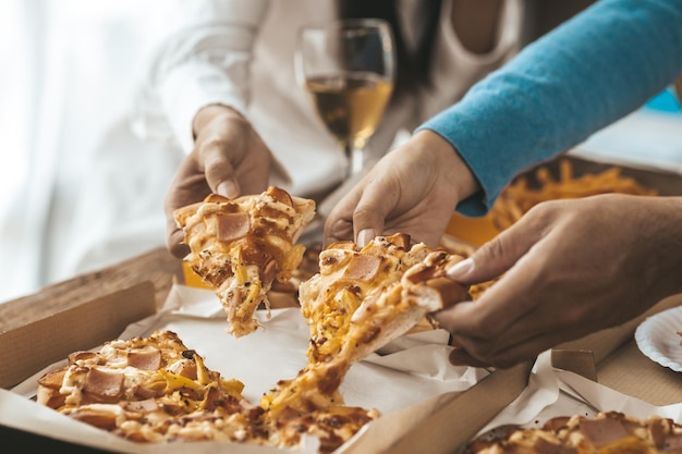 Mãos pessoas pegando pizza em uma bandeja para comer festas da empresa de inicialização festas de ano novo reuniões anuais da empresa bebidas alcoólicas festa dos funcionários da empresa idéias de catering celebrações de pizza