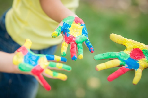 Mãos pintadas contra o fundo verde da primavera