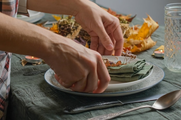 Mãos pondo uma mesa para a celebração de Ação de Graças Festa de férias outonal