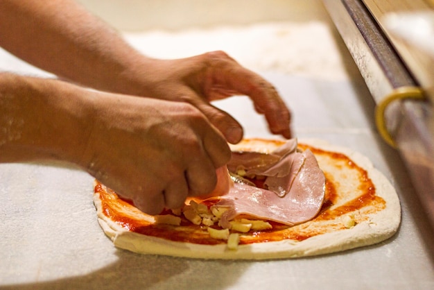 Foto mãos preparando pizza