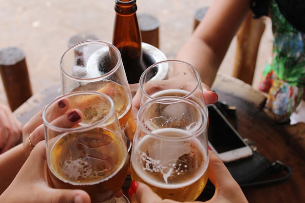 Mãos próximas segurando copos de vinho