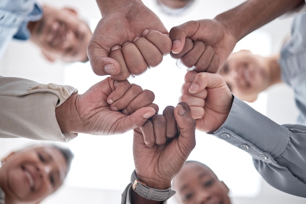 Foto mãos, punhos, círculo de grupo e equipe comemoram o sucesso da missão de cooperação comunitária ou a feliz conquista corporativa abaixo, veja as metas e o comprometimento da equipe, a solidariedade e o apoio ao trabalho em equipe da sociedade