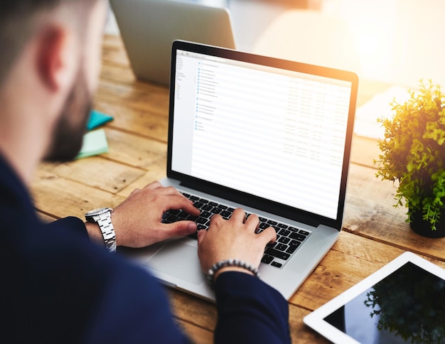 Mãos que foram feitas para produzir resultados Foto recortada de um empresário usando um laptop em sua mesa de trabalho