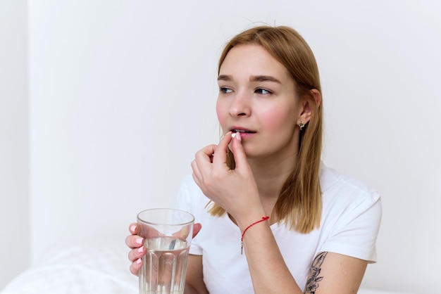 mãos seguram um copo d'água e um comprimido para a dor. cuidados de saúde, conceito de suplementos médicos.