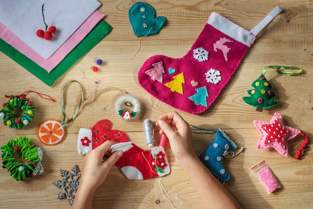 Foto mãos segurando agulha e costurando meia de natal para decoração de natal e ano novo