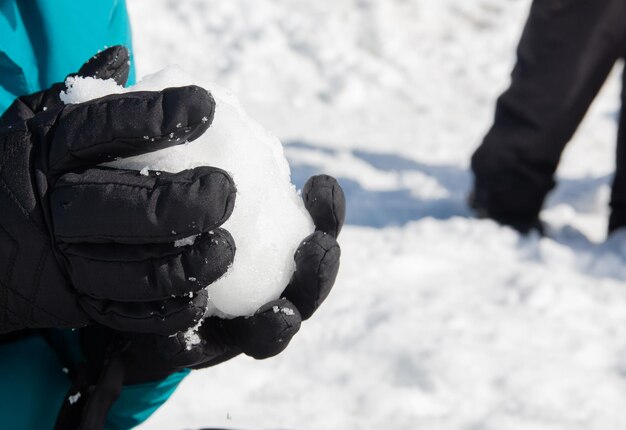 Foto mãos segurando bola de neve