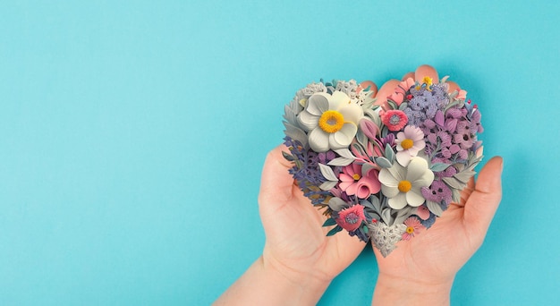 Mãos segurando coração humano com amor de flores e conceito de emoção pessoa de bom coração ajuda