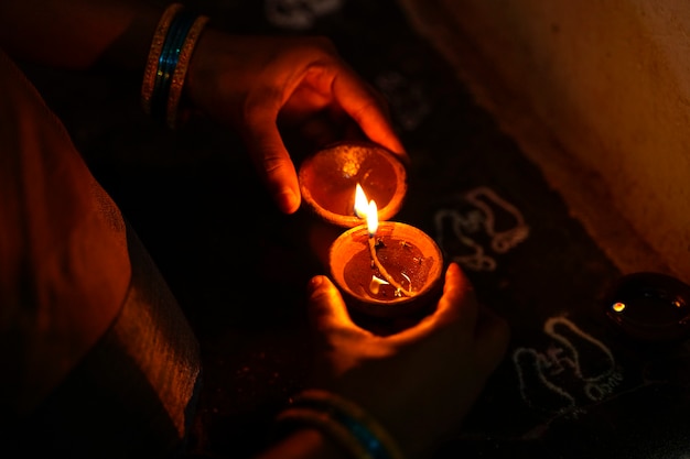 Mãos segurando lâmpadas Diwali