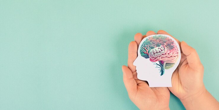 Foto mãos segurando o cérebro humano de cabeça de papel com autocuidado de flores e conceito de saúde mental positivo