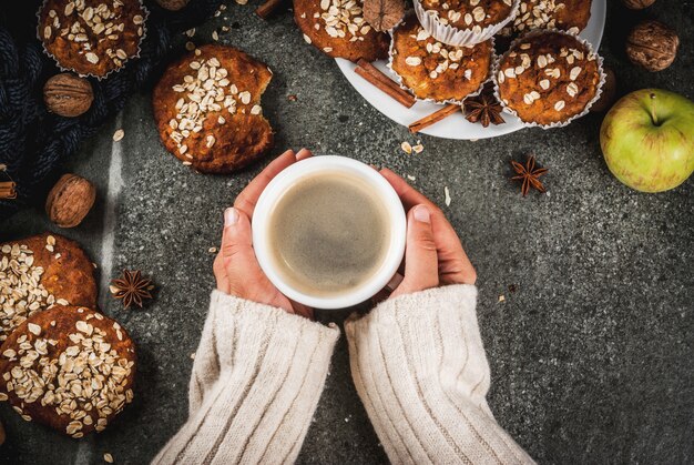 Foto mãos segurando um café rodeado por bolos