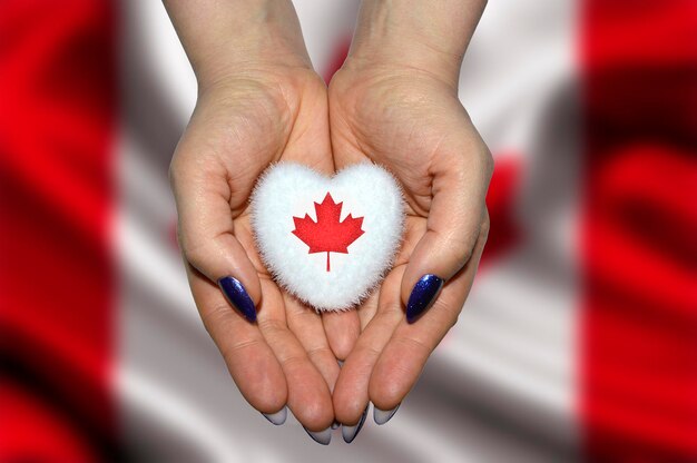 Mãos segurando um coração com bandeira do conceito de feriado do Dia do Canadá Canadá