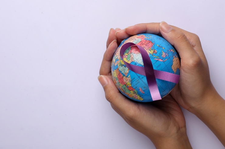 Foto mãos segurando um globo com uma fita roxa para a conscientização do câncer