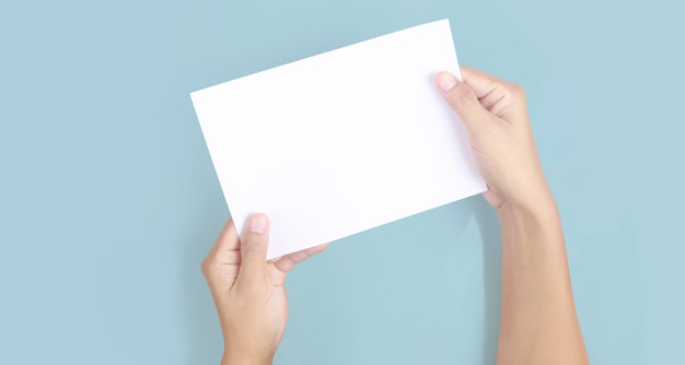 Mãos segurando um papel em branco para um papel de carta