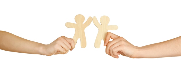Mãos segurando um par de figuras de madeira isoladas em branco
