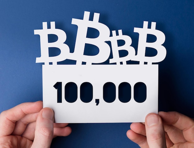 Mãos segurando um sinal de preço de mercado de criptomoeda bitcoin