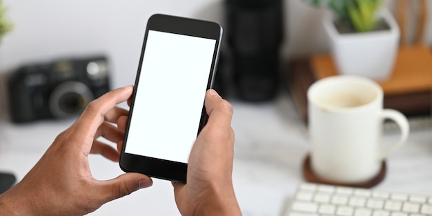 Foto mãos segurando um smartphone com tela em branco branca