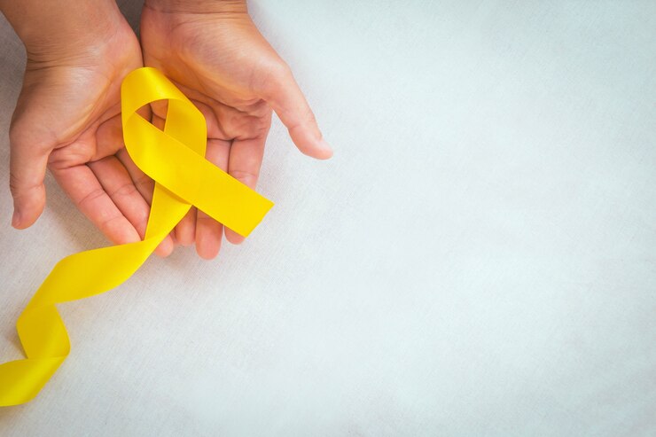 Foto mãos segurando uma fita amarela com espaço de cópia câncer ósseo conscientização do sarcoma conscientização do câncer infantil cholangiocarcinoma mundo do câncer de vesícula biliar dia da prevenção do suicídio conceito de seguro de saúde