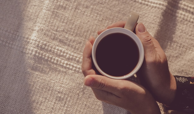 mãos segurando uma xícara de café