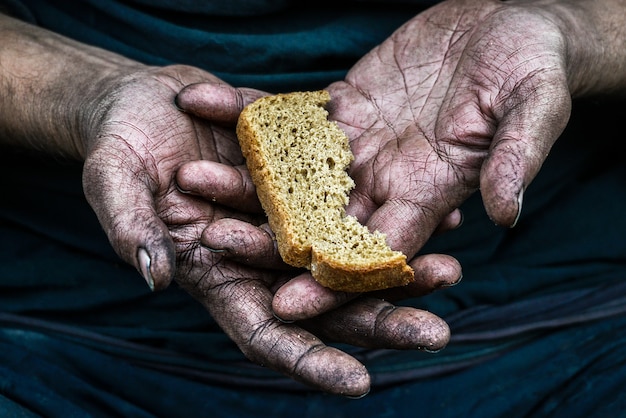 Foto mãos sujas pobre homem sem-teto com pedaço de pão na sociedade do capitalismo moderno