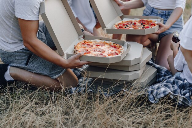 Mãos tirar pizza de caixas no piquenique