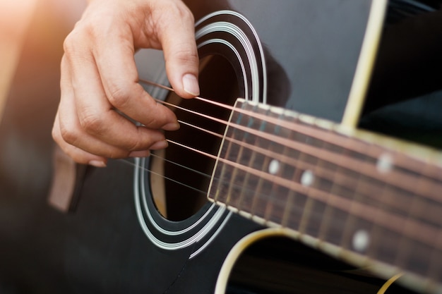 Mãos tocando violão.