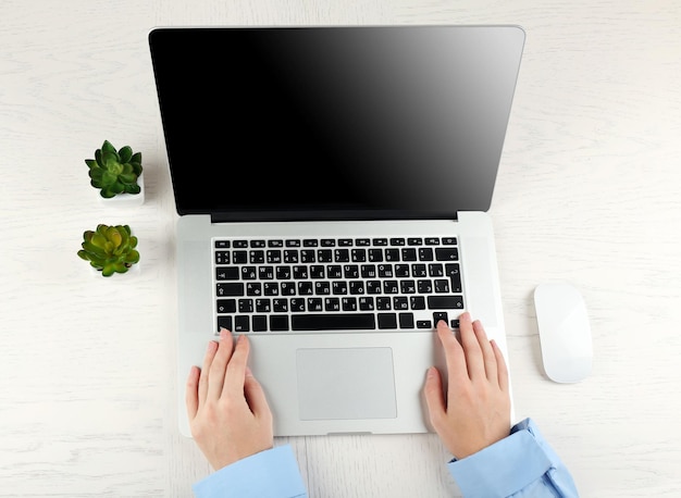 Foto mãos trabalhando no escritório com laptop em uma mesa branca