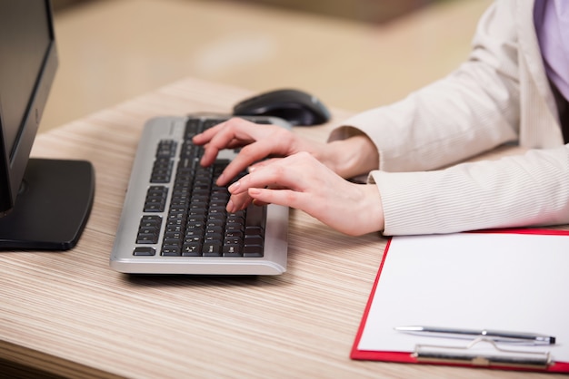 Mãos trabalhando no teclado no escritório