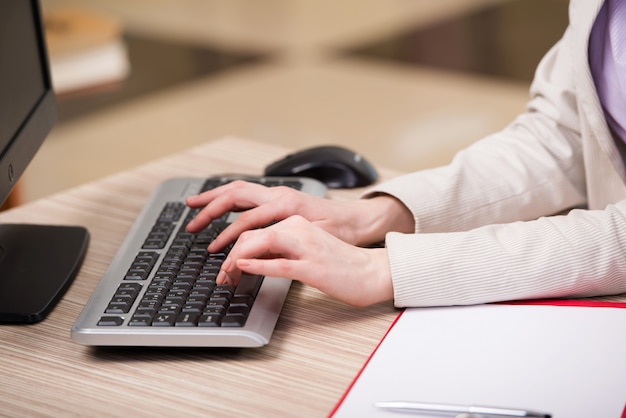 Mãos trabalhando no teclado no escritório