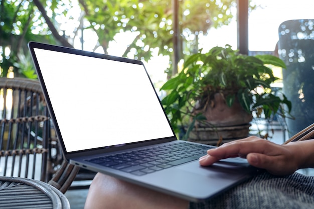 mãos usando e tocando no touchpad com tela de desktop branca em branco enquanto está sentado ao ar livre