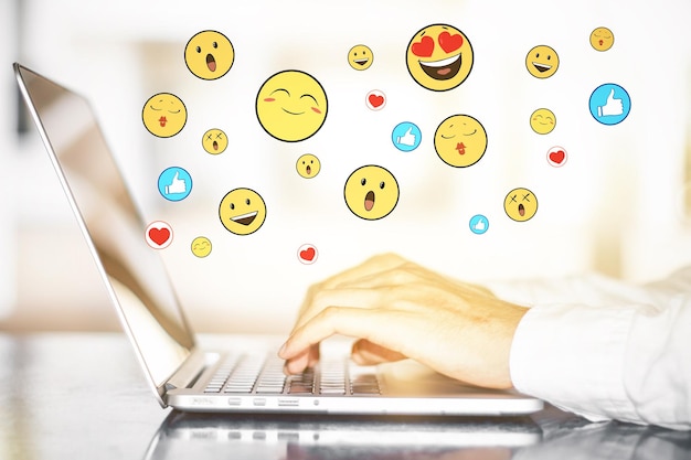 Mãos usando laptop com smileys