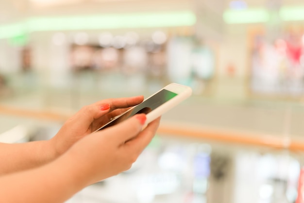 Mãos usando um smartphone móvel e tirando uma foto na exibição de uma loja de roupas comprando conceito on-line