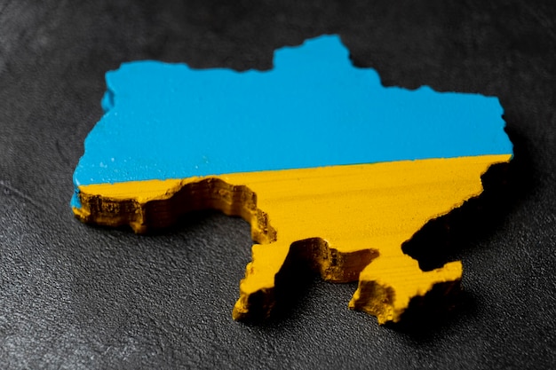 Mapa da Ucrânia esculpido em madeira e pintado nas cores da bandeira ucraniana