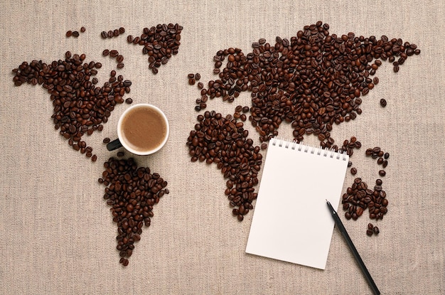 Mapa do mundo feito de grãos de café e caderno para escrever