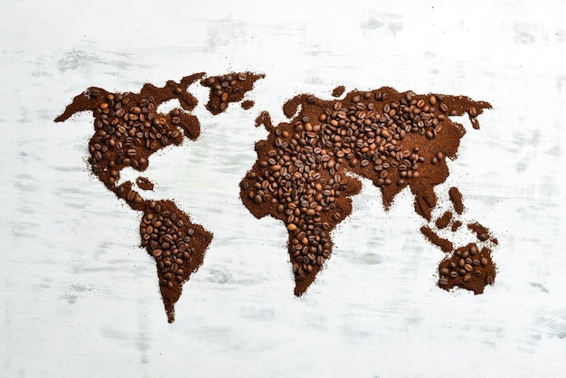 Mapa do mundo Grãos de café perfumados em um fundo branco de madeira Bebidas tradicionais Vista superior