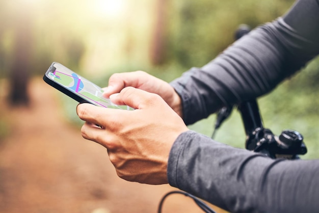 Mapa GPS e ciclista com smartphone para orientação digital de viagem em trilha de fitness na natureza Tecnologia móvel para segurança de segurança de ciclo e ajuda para homem viajando em local remoto