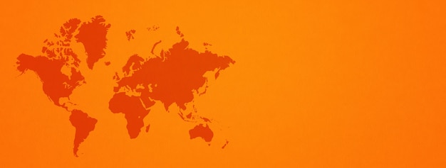 Mapa del mundo aislado en la superficie de la pared naranja