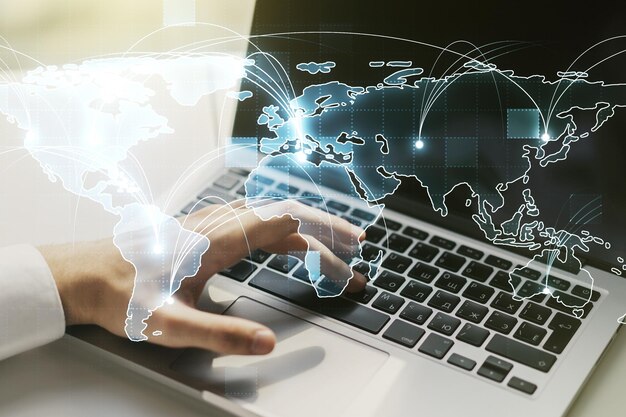 Mapa del mundo digital gráfico abstracto con conexiones y manos escribiendo en el teclado de la computadora sobre el concepto de globalización de fondo Multiexposición