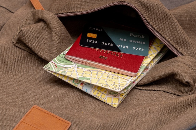 Mapa turístico, tarjeta, pasaporte en el bolsillo de la mochila de viaje.