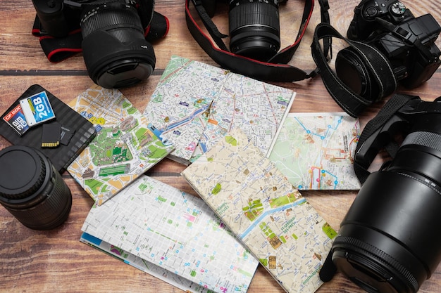 Foto mapas da cidade ao lado de câmeras e passaporte em uma mesa de madeira conceito de férias viaja viajantes