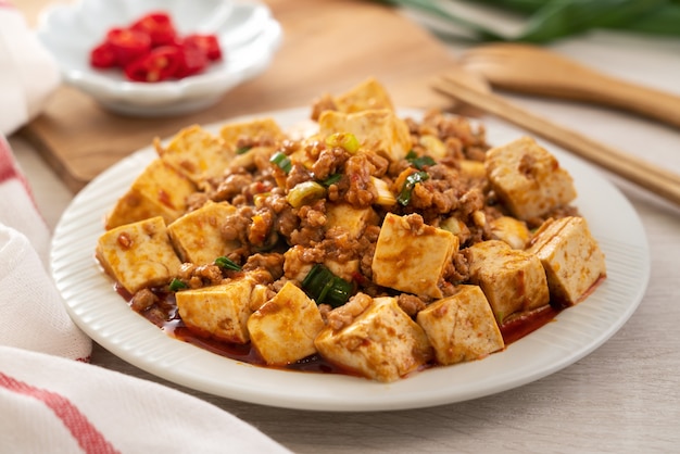 Mapo tofu, tofu salteado con salsa picante picante en plato blanco, famosa cocina gourmet china.