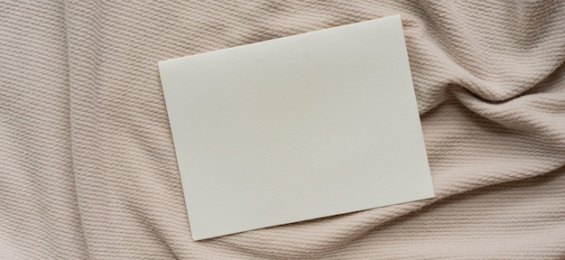 Maqueta blanca de papel en blanco sobre fondo de textura de tela ondulada y arrugada para un diseño minimalista