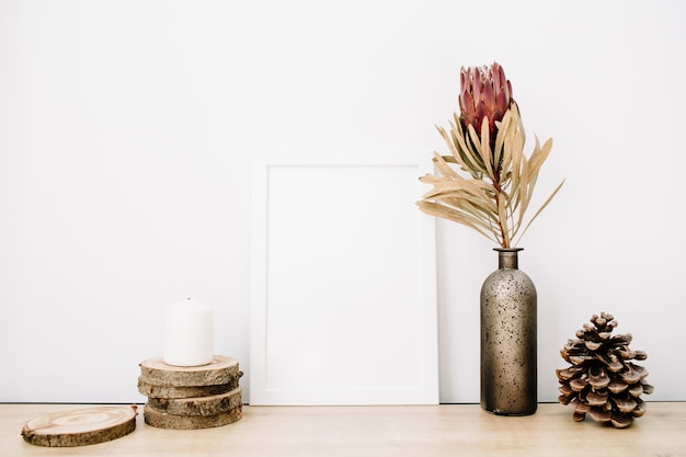 Maqueta en blanco de marco de fotos con flor de protea y cosas de moda en fondo blanco.