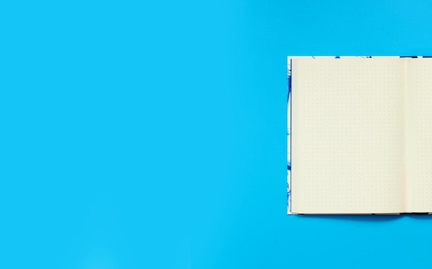 Maqueta de un bloc de notas abierto sobre un fondo azul Vista superior plano Lay Diario para espacio de copia de notas