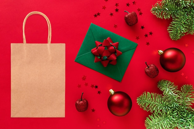 Maqueta de bolsa de compras de Kraft en un espacio de estilo navideño. Ramas de árbol de Navidad, adornos