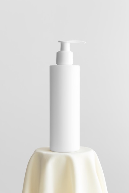 Maqueta de botella de dispensador de champú cosmético blanco en el textil amarillo