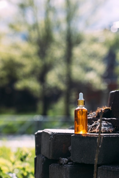 maqueta de botella con gotero sobre fondo de naturaleza