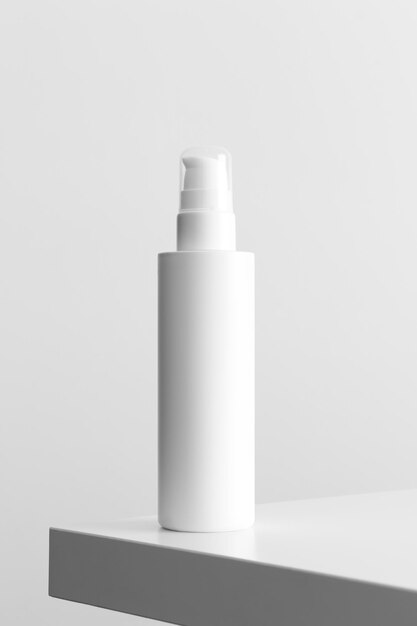 Maqueta de botella de loción cosmética blanca sobre una mesa blanca