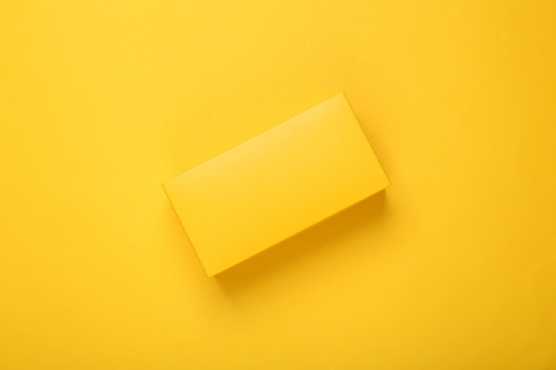 Maqueta de caja amarilla sobre fondo amarillo