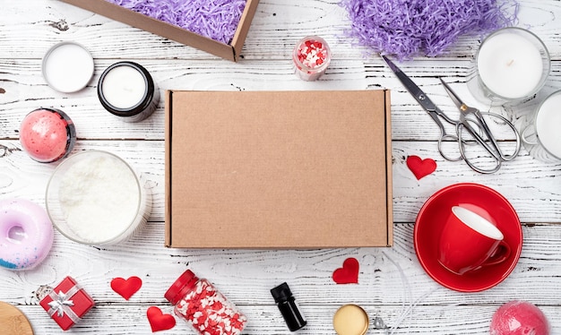 Maqueta de caja de regalo de temporada para el día de san valentín con taza de vela roja y dulces en forma de corazón