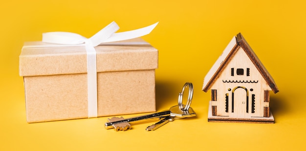 Maqueta de casa en miniatura, regalo y llaves. Inversión, bienes raíces, hogar, vivienda